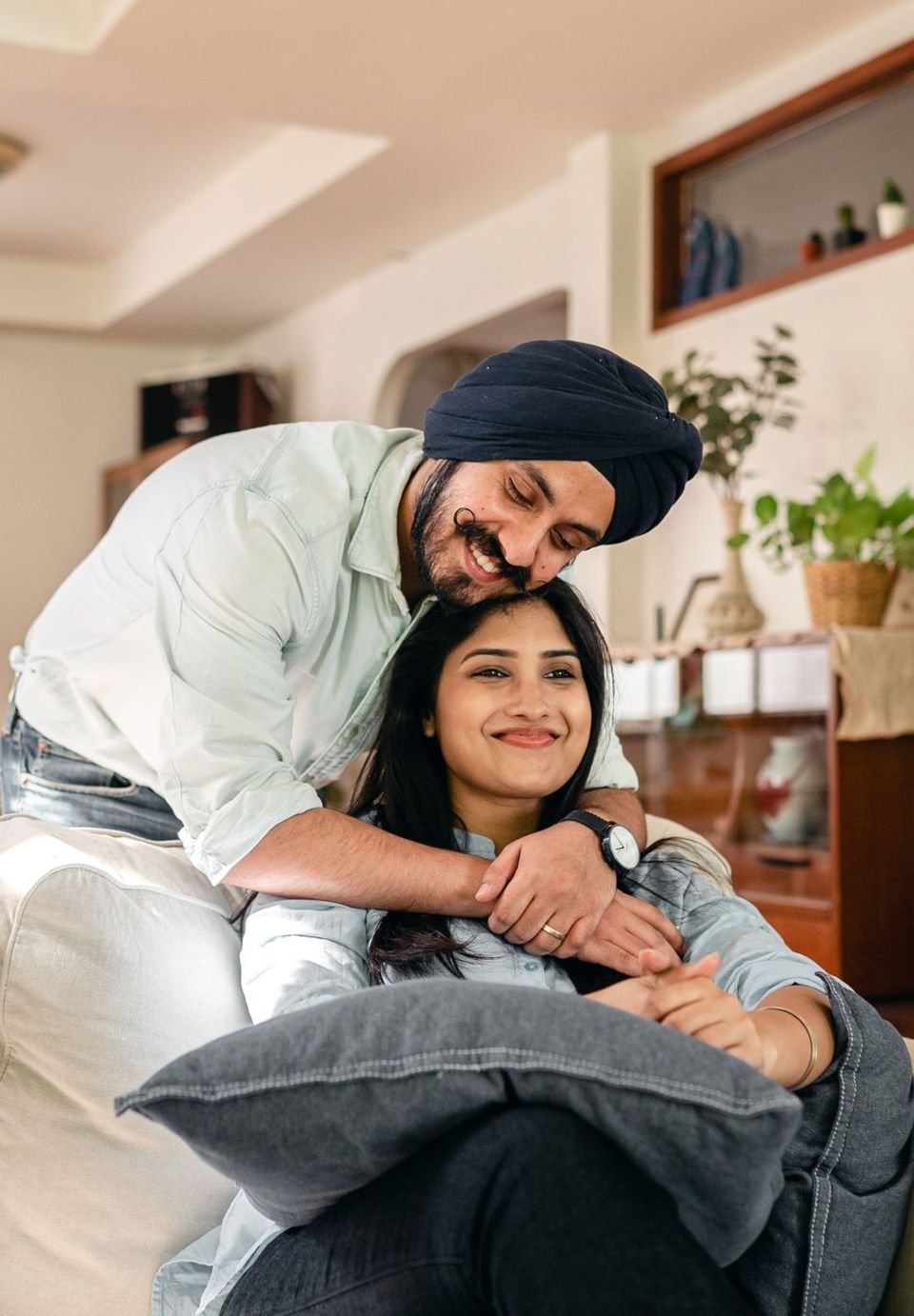 Couple smiling together on a sofa at home