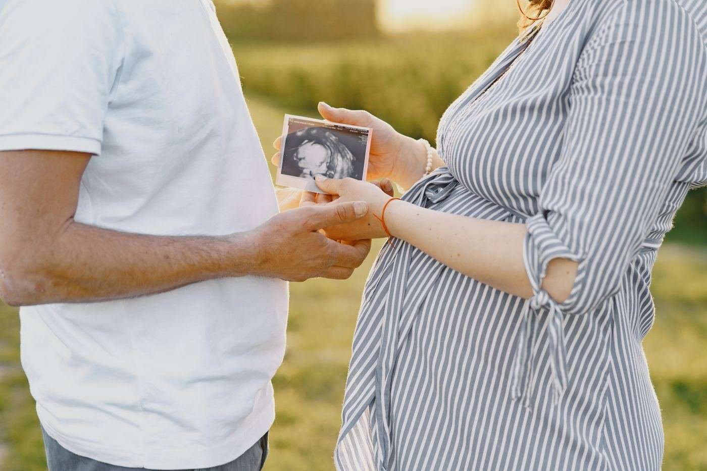 Expectant couple holding an ultrasound scan photo