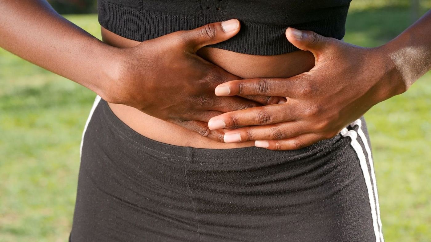 Woman holding her lower abdomen because of period pain